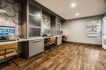 A modern kitchen with wooden floors and a patterned wallpaper